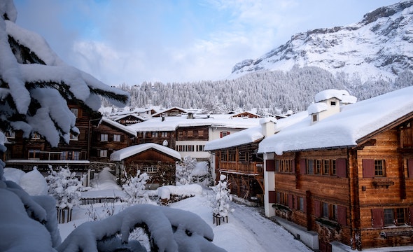 Snow-covered Swiss chalet in winter with pristine white landscape